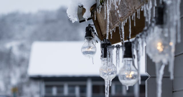 Frozen Light Bulbs hanging outside a house in the middle of the winter. Protecting Your Pipes During the Winter.